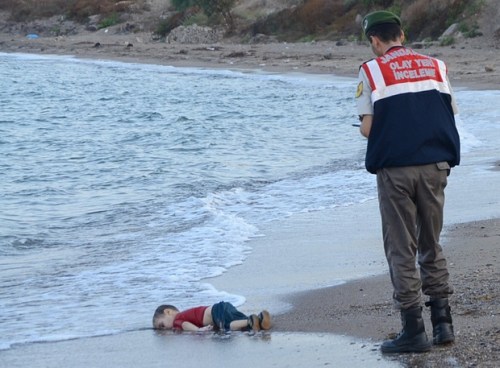 A Turkish policeman discovers the drowned body of young Syrian refugee, presumably drowned as his family tried to flee the war